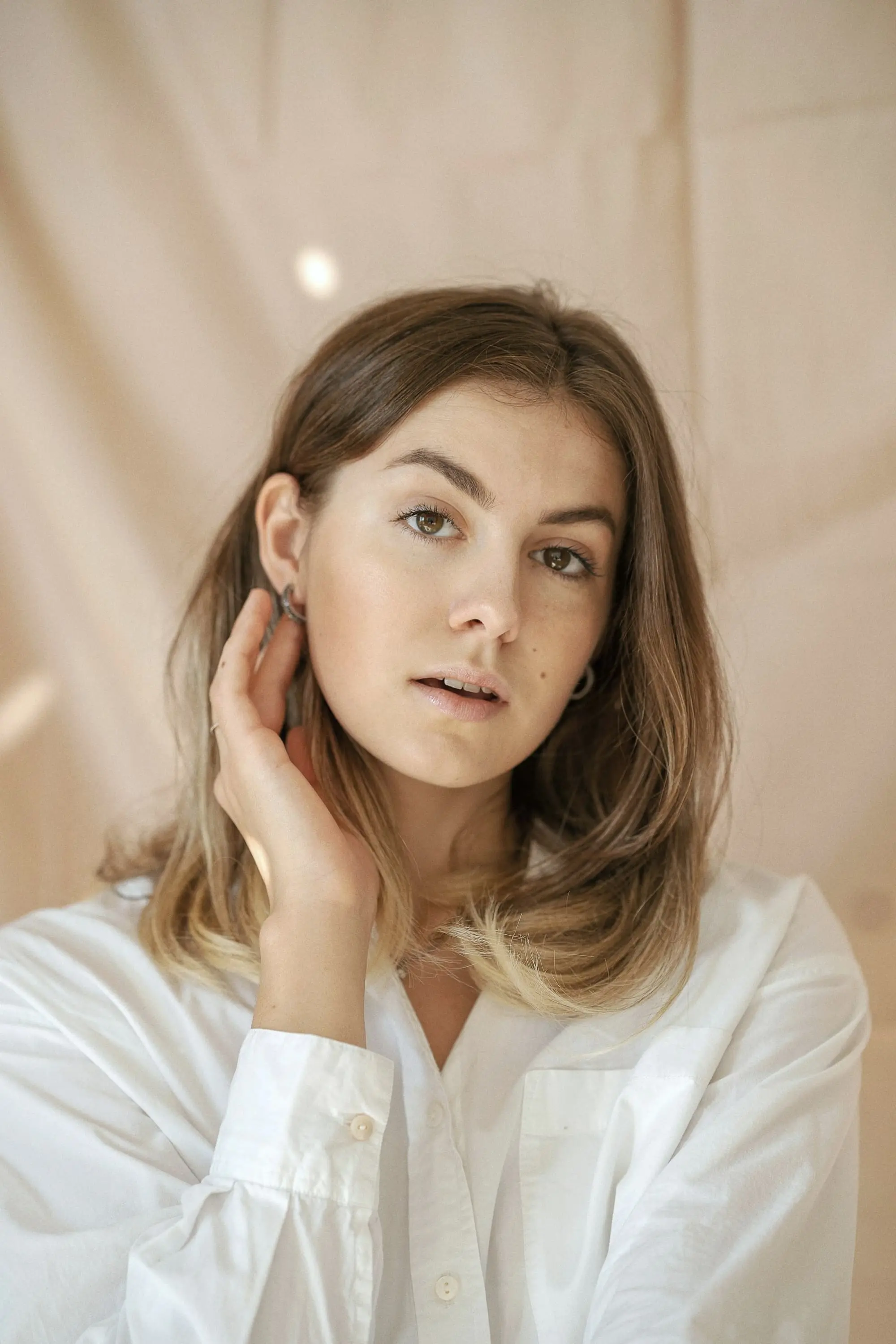 Portrait of a person with long hair in warm, soft light