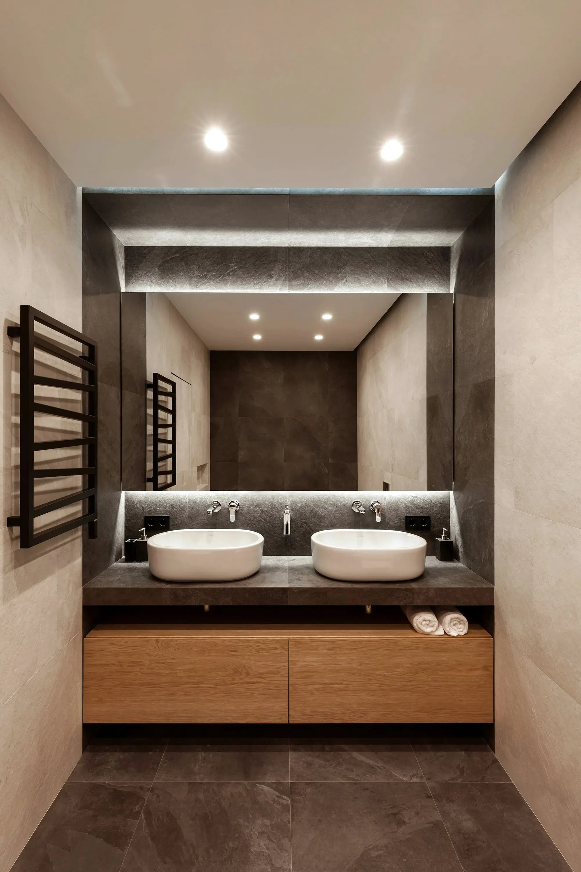Bathroom with two stone vessel basins, a heated towel rail and soft ceiling light
