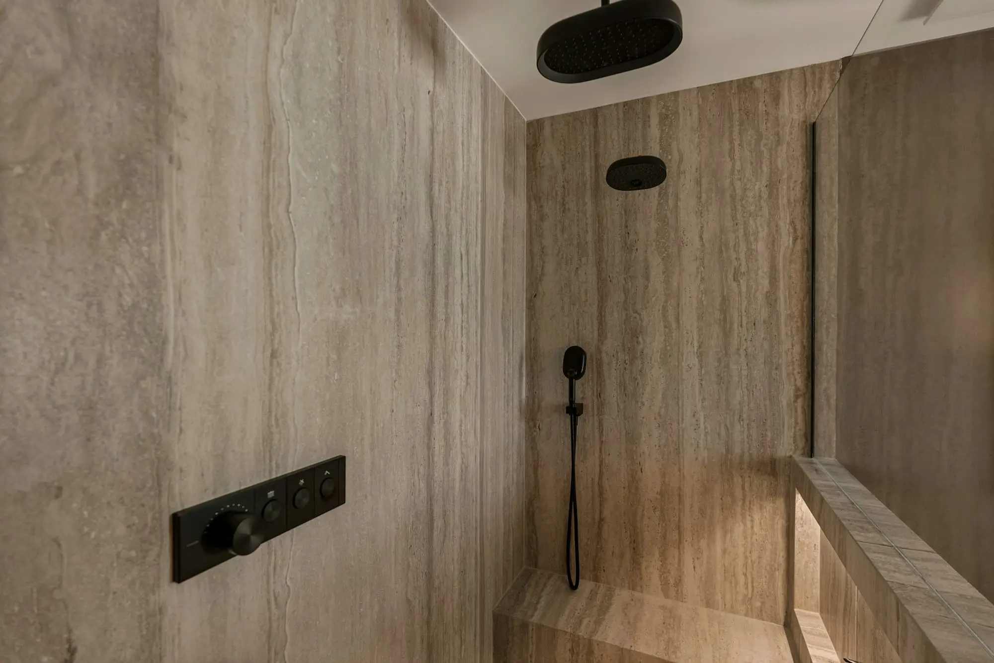 Walk-in shower with a rain head set in vein-cut travertine