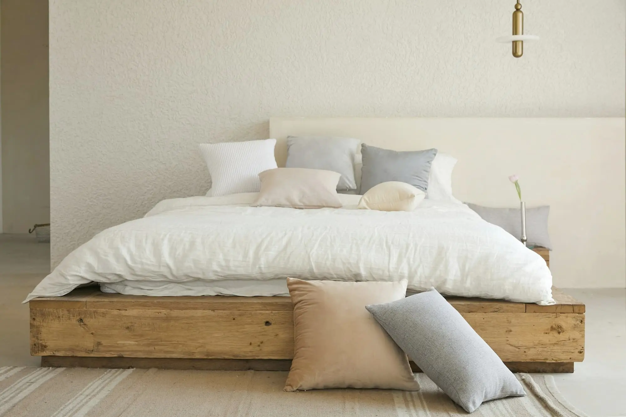 Bedroom with a low oak bed, linen bedding and soft daylight