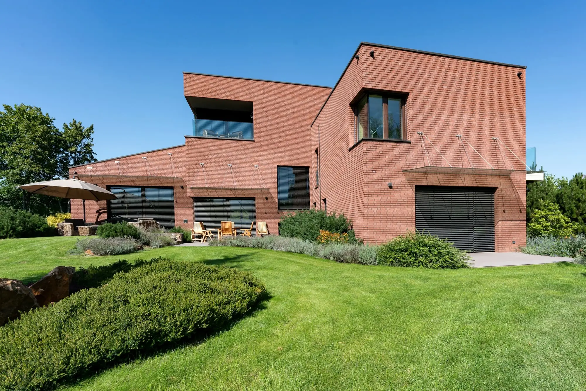 Contemporary red brick house with a flat roof, garage and a clipped lawn