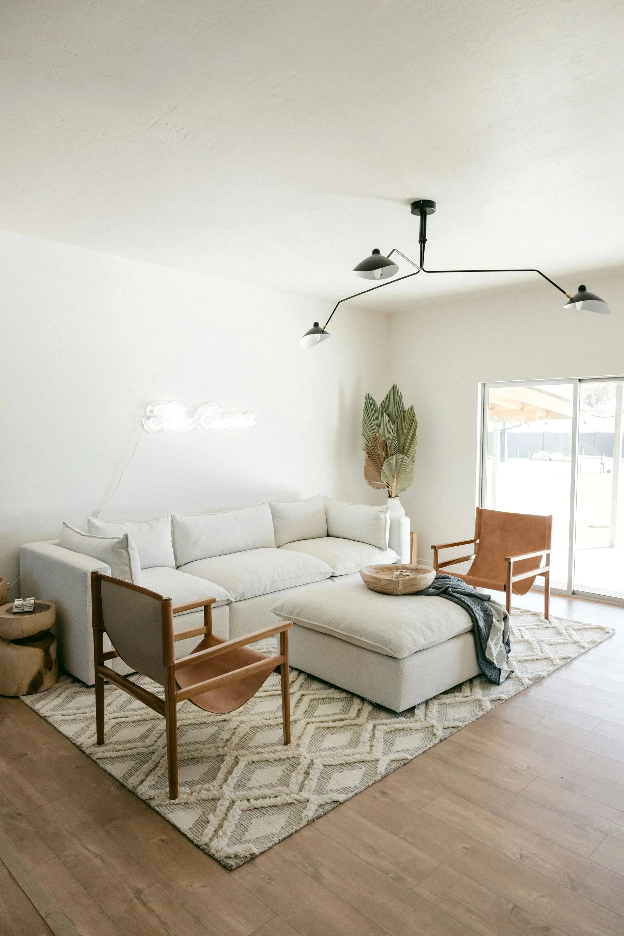 Cream sofa, leather armchair and sliding glass doors in a white living room