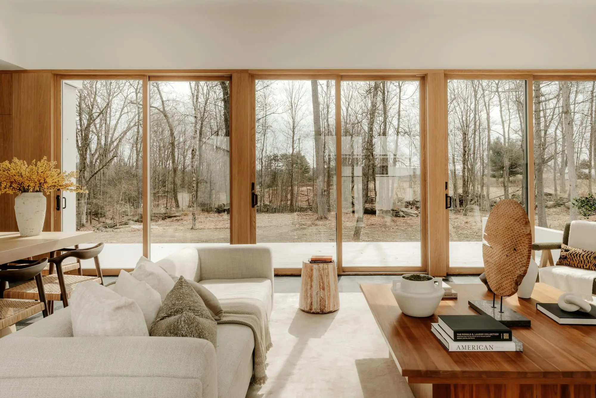 Living room with tall oak-framed sliding doors looking out over trees