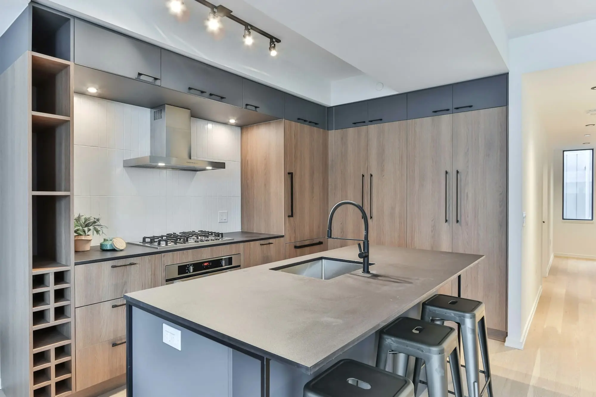 Kitchen with oak cabinets, a concrete-look island and a black tap