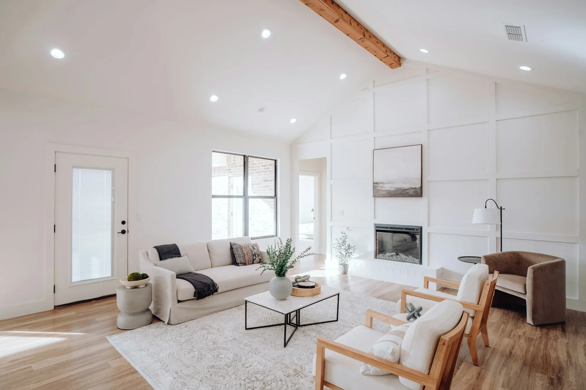 Bright open-plan living room with an exposed timber beam and a fireplace