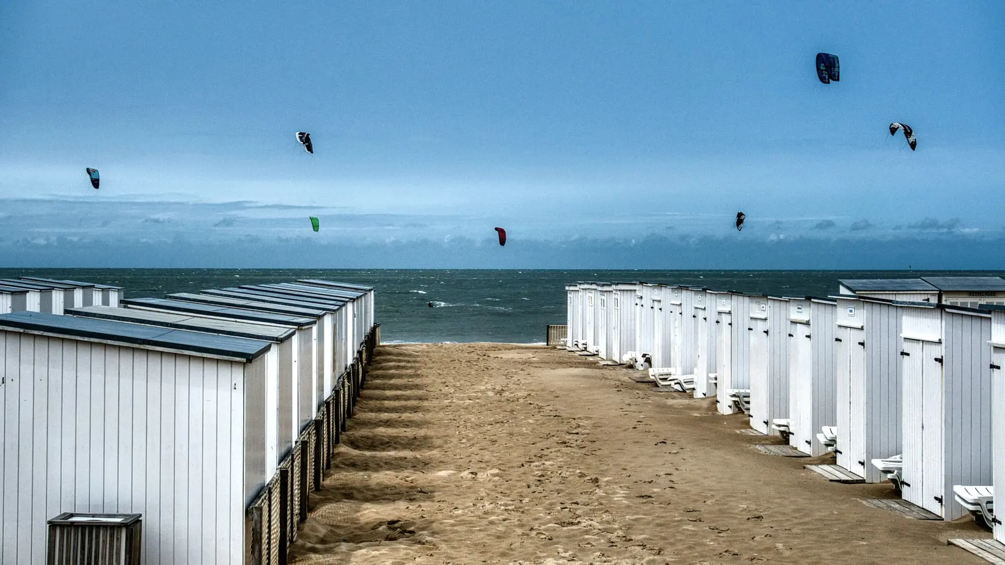 White beach huts and kite surfers on the Belgian coast